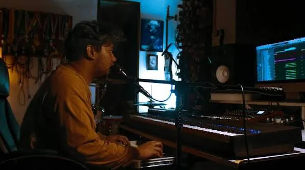 Godwayne composing in the studio